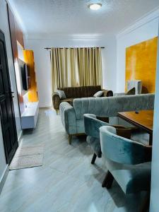 een woonkamer met een bank en een tafel bij Malaika Homes Jinja in Jinja