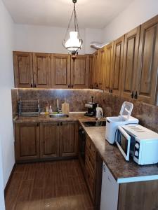 a kitchen with wooden cabinets and a microwave on a counter at Villa Victoria in Stoykite