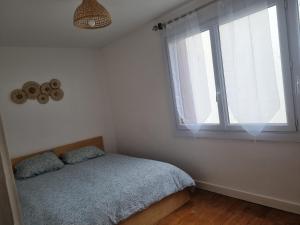 a bedroom with a bed and a large window at 5 pièces traversant proche paris in Poissy
