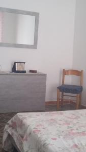 ein Schlafzimmer mit einem Bett, einem Stuhl und einem Spiegel in der Unterkunft Da Anto in Trivio
