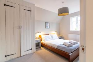 a white bedroom with a bed and a window at Chapel View in Loughborough