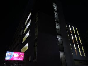 a building with a neon sign in front of it at night at Y STAY HOMESTAY in Tirupati