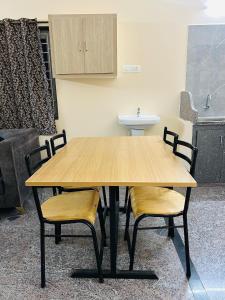 a wooden table with two chairs and a sink at Y STAY HOMESTAY in Tirupati
