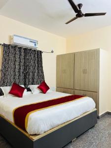a bedroom with a large bed with red pillows at Y STAY HOMESTAY in Tirupati