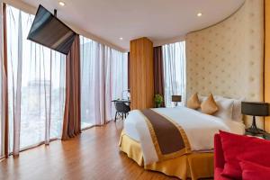 a hotel room with a large bed and a television at Bay Hotel Ho Chi Minh in Ho Chi Minh City