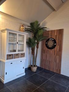 a room with a white cabinet and a palm tree at Guesthouse 66 in Lommel