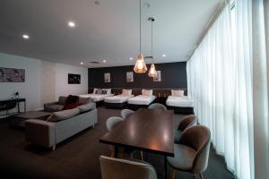 een woonkamer met een bank en een tafel en stoelen bij Sfera's Park Suites & Convention Centre in Adelaide