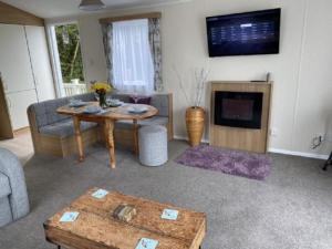 a living room with a table and a fireplace at Flamingos Rest in Newton on the Moor