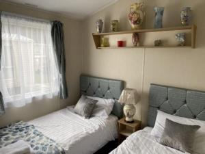 a bedroom with two beds and a window at Flamingos Rest in Newton on the Moor