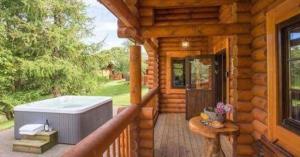 a porch of a log cabin with a hot tub at Gingerbread Log Cabin in Eshott
