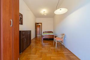 einen Flur mit einem Bett und einem Stuhl in einem Zimmer in der Unterkunft Family One bedroom apartment with Panoramic city view in Budva