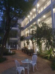 a courtyard with tables and chairs in front of a building at โรงแรม ปารวี บูทีค เชียงราย (Parawee Boutique Hotel) in Chiang Rai