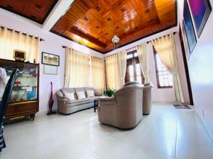 a living room with two couches and a table at NHÀ ANH THÀNH HOMESTAY in Da Lat