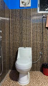 y baño con ducha y aseo blanco. en TULDA BAMBUSA RESORT, en Kāziranga