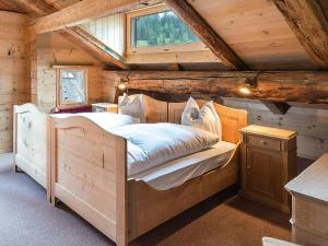 ein Schlafzimmer mit einem Bett in einer Holzhütte in der Unterkunft Hotel Rhätia in Luzein