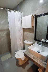 a bathroom with a sink and a toilet and a mirror at Monaco Hotel in Taytay