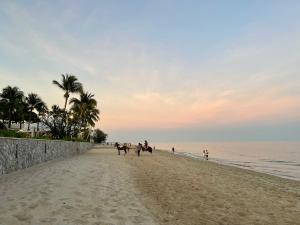 eine Gruppe von Menschen, die am Strand reiten in der Unterkunft Hua Hin Blue Lagoon-Pool Access in Cha-am