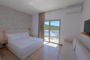a bedroom with a bed and a couch and a television at Villa Juna Beach in Sarandë +136 photos