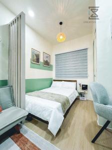 a bedroom with a bed and a chair at CreativeSpace-Mactan2 in Lapu Lapu City