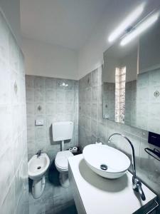 La salle de bains est pourvue d'un lavabo, de toilettes et d'un miroir. dans l'établissement CASA VACANZA A 100 METRI DAL MARE, à Imperia