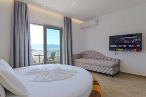 a bedroom with a bed and a couch and a window at Villa Juna Beach in Sarandë