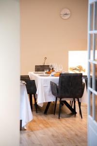 a dining room table with a white tablecloth and chairs at Sechex Nous in Margencel