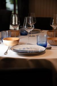 a table with two wine glasses and plates on it at Sechex Nous in Margencel