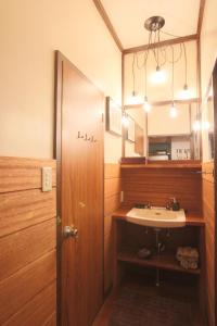 a bathroom with a sink and a mirror at Lucky Duck Cabin Myoko in Myoko