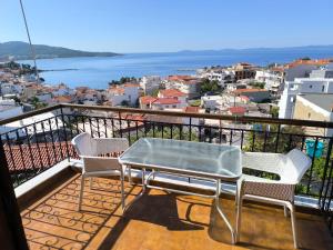 - un balcon avec une table et deux chaises et l'océan dans l'établissement House Mistral, à Neos Marmaras