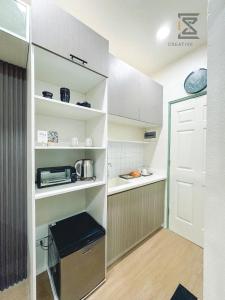 a small kitchen with white shelves and a door at CreativeSpace-Mactan2 in Lapu Lapu City
