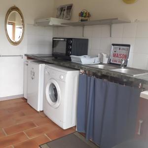 a kitchen with a washing machine and a microwave at La limandière in Morancé