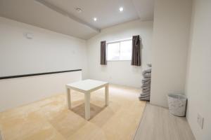 um quarto branco com uma mesa branca em official TR House Osaka peace and quite area 1bathrooms up to 4people em Osaka