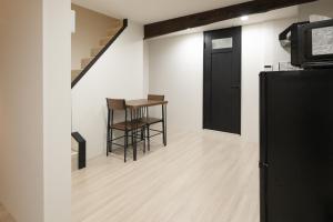 a room with a black door and a table and stool at Official TRhouses 15 minutes to Shinsaibashi, Kuromon Market and Namba in Osaka