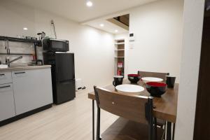 uma cozinha com uma mesa de madeira e um frigorífico em official TR House Osaka peace and quite area 1bathrooms up to 4people em Osaka