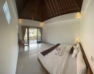 a bedroom with a large white bed in a room at Bupon House Jepun Room in Gianyar