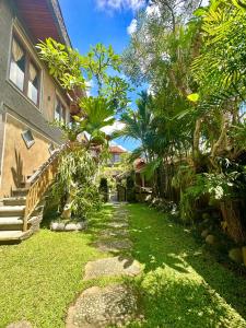 a garden with a walkway next to a house at Bupon House Jepun Room in Gianyar