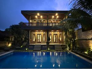 a house with a swimming pool in front of it at Bupon House Ubud in Gianyar