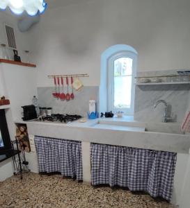 uma cozinha com um lavatório e um fogão em Un tuffo vintage tra mare_monti em Pianavia