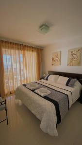 een slaapkamer met een groot bed en een raam bij SUNRISE ATALAYA Amanecer suite in Mojácar