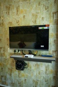 a television on a shelf on a wall at Hotel Alpenglow in Yercaud