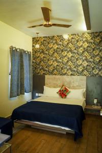a bedroom with a bed and a ceiling fan at Hotel Alpenglow in Yercaud