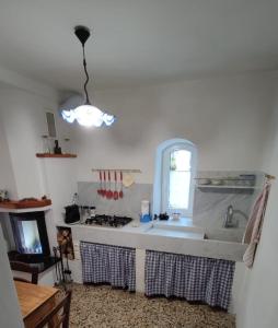 uma cozinha com um lavatório e uma janela em Un tuffo vintage tra mare_monti em Pianavia