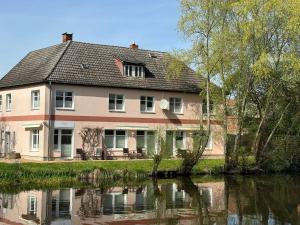 una casa grande junto a un cuerpo de agua en Waterkant, en Lübz