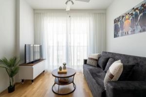 een woonkamer met een bank en een tv bij HM • Trendy 1BR, Direct City Access in Wenen