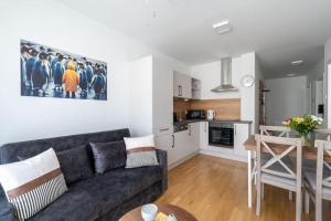een woonkamer met een bank en een tafel en een keuken bij HM • Trendy 1BR, Direct City Access in Wenen