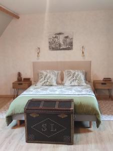 een slaapkamer met een bed met een kofferbak bij Ailes et Iles in Pleudaniel