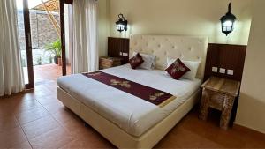 Un dormitorio con una gran cama blanca y una ventana en Vamana Bangsal, en Pawenang