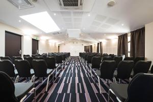 a conference room with black chairs and a screen at Moulin de Vernègues Hôtel & Spa in Mallemort +58 photos