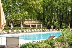 a swimming pool with lounge chairs and a resort at Moulin de Vernègues Hôtel & Spa in Mallemort