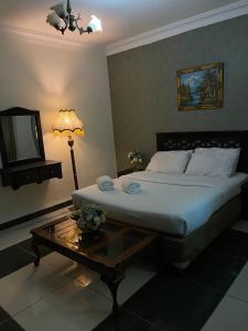 a bedroom with a large bed and a coffee table at أجنحة أبو قبع الفندقيةAbu Quboh Hotel Suite Apartment in Amman
